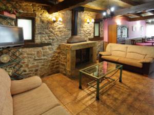 a living room with a fireplace and a stone wall at Casa Rural Sierra de Tabanera in San Andrés de Soria
