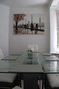 een eetkamer met een tafel en een foto aan de muur bij Cosy 3 bedroom house in quiet residential area in Manchester