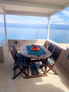 een tafel en stoelen op een balkon met uitzicht op de oceaan bij Filis mare apartment in Xylokastron