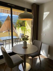 a dining room with a table and chairs and a window at Servotel Castagniers in Castagniers