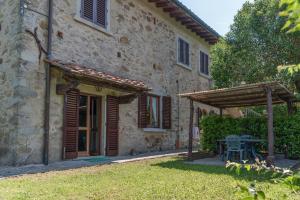 an old stone house with a table and a patio at Universal Harmony - Poiana in Dicomano