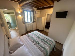 1 dormitorio con 1 cama en una habitación con ventana en Casa Aldobrandeschi Saturnia, en Saturnia