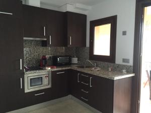 a kitchen with black cabinets and a microwave at Apartamento Amarna in Benalmádena