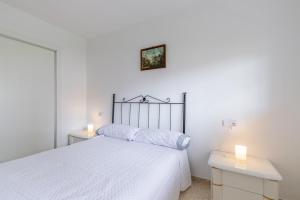 1 dormitorio blanco con 1 cama y 2 mesas en Coblanca 7, en Benidorm
