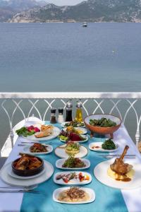 een tafel met borden eten op een tafel met water bij BÜŞRA SELİMİYE in Marmaris