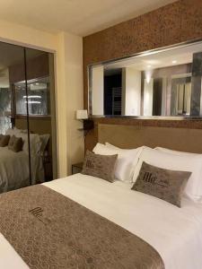 Ale Suite Sea Side View - Hotel Arizona في ريتشيوني: غرفة نوم بسرير ابيض كبير ومرآة