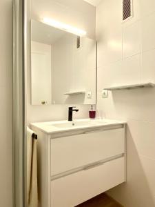 Baño blanco con lavabo y espejo en Apartamento con 3 habitaciones, terraza y jardin comunitario con piscina en Sant Antoni de Calonge en Sant Antoni de Calonge