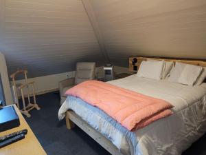 a bedroom with a bed and a desk with a laptop at Auberge Le Four à Pain in Petite-Rivière-Saint-François