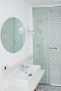 a white bathroom with a sink and a mirror at Del Pescador Hotel Cabañas in Frutillar