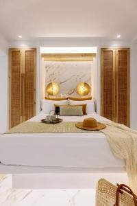 a white bedroom with a bed with a hat on it at Venus Suite with Hot Tub in Agios Prokopios