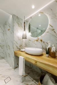 y baño con lavabo y espejo. en Venus Suite with Hot Tub, en Agios Prokopios