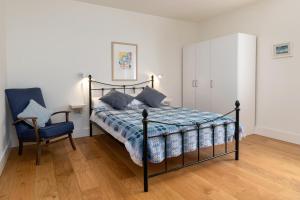 a bedroom with a bed and a chair and a cabinet at Cefn Ceiriog in Llangollen