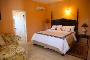 - une chambre avec un grand lit et un canapé dans l'établissement Jannetta's @Whimhill Bed & Breakfast, à Negril