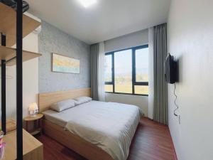 1 dormitorio con cama y ventana grande en Tít Mít HomeStay en Cao Bằng