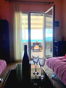 een woonkamer met een fles en twee glazen op een tafel bij Filis mare apartment in Xylokastron