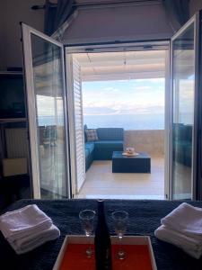 a table with two glasses and a view of a patio at Filis mare apartment in Xylokastron
