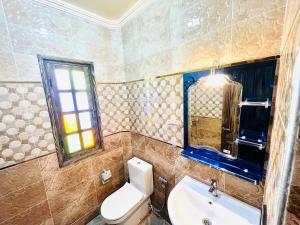 a bathroom with a toilet and a sink and a window at Unique Villa Castle With Pool in Essaouira +47 photos