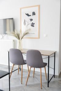 a dining room table with two chairs and a picture at #T33 Chic 2BR apartment in the centre of Volos in Volos