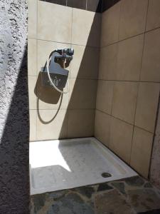 une cabine de douche avec un tuyau sur un mur dans l'établissement Casa Davia. Studio indépendant meublé., à Furiani