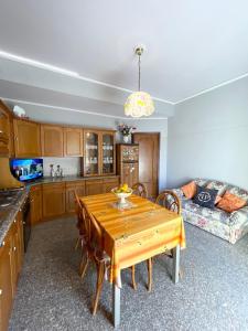 a kitchen with a wooden table and a couch at Home and Relax ROOMS in Furnari