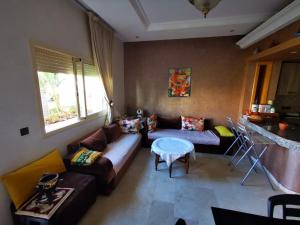 a living room with a couch and a table at Savanah Beach Residence in Casablanca +28 photos