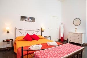 1 dormitorio con cama naranja y almohadas rojas en Antico Borgo en Catania