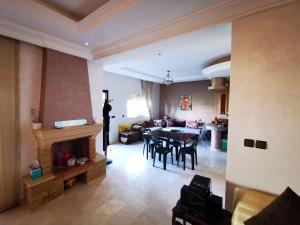 a living room with a fireplace and a dining room at Savanah Beach Residence in Casablanca