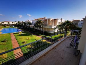 a balcony with a view of a yard and a pool at Savanah Beach Residence in Casablanca