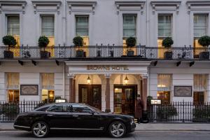 um carro preto estacionado em frente a um hotel castanho em Brown's Hotel, a Rocco Forte Hotel em Londres