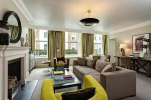 a living room with a couch and a fireplace at Brown's Hotel, a Rocco Forte Hotel in London