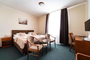 pokój hotelowy z łóżkiem, stołem i krzesłami w obiekcie Hotel Panorama w Pilznie +37 zdjęć