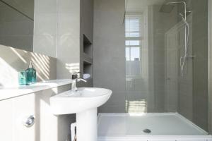 a white bathroom with a sink and a shower at Luxury Apartment/Flat Edinburgh City Centre in Edinburgh