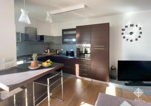 a kitchen with wooden cabinets and a large clock on the wall at Infinito - Attico sul mare in Vieste