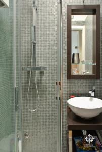a bathroom with a sink and a glass shower at Infinito - Attico sul mare in Vieste