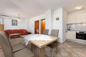 une cuisine et une salle à manger avec une table et des chaises dans l'établissement Apartments Barjaktarić, à Malinska