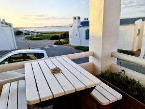 a wooden bench on a balcony with a shell on it at Flamink Beach View Cottage in Paternoster in Paternoster