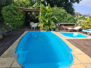 una piscina azul con terraza y cenador en Mira Playa Geribá, en Búzios
