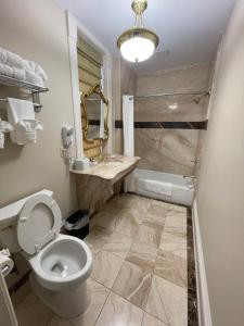 a bathroom with a toilet and a sink and a tub at The Union Hotel in Everett +33 photos