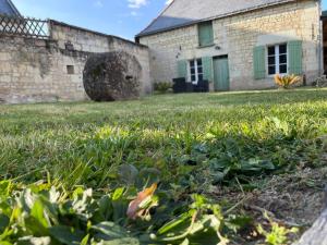 un campo de hierba con un edificio en el fondo en Le colombier, en Le Coudray-Macouard