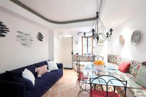 ein Wohnzimmer mit einem blauen Sofa und einem Glastisch in der Unterkunft Sikelia Apartment Taormina in Taormina