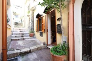 eine Gasse mit Topfpflanzen neben einem Gebäude in der Unterkunft Sikelia Apartment Taormina in Taormina