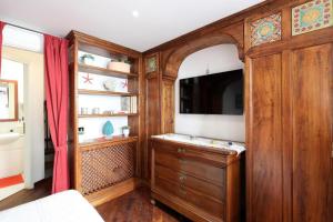 een slaapkamer met een houten kast en een tv. bij Sikelia Apartment Taormina in Taormina
