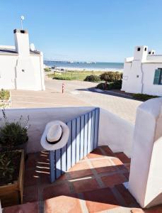 a hat sitting on a railing next to the beach at Flamink Beach View Cottage in Paternoster in Paternoster