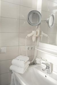 La salle de bains est pourvue d'un lavabo, d'un miroir et de serviettes. dans l'établissement Hotel Seehof Norderney OHG, à Norderney