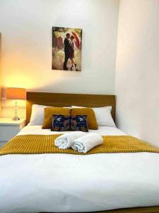 a bedroom with a bed with two towels on it at Comfortable flat in Central London in London