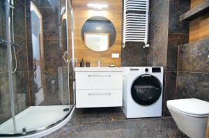 a bathroom with a washing machine and a toilet at Apartament Katowice Meteorologów in Katowice