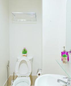 Baño blanco con aseo y lavamanos en 11F Condo in Limketkai Center CDO, en Cagayan de Oro