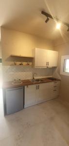 an empty kitchen with white cabinets and a ceiling at Stavroula Studios in Paleokastritsa