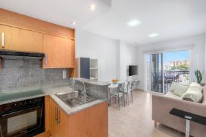 a kitchen with a sink and a living room at Lopimar Guillen de Castro in Canet de Berenguer