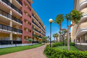 a pathway in the courtyard of a apartment building with palm trees at Lopimar Guillen de Castro in Canet de Berenguer